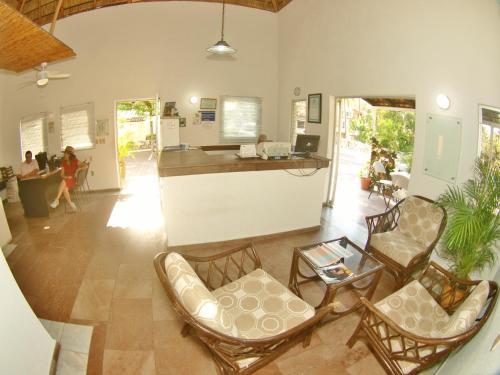 a living room with chairs and a counter and people at Villas del Palmar Manzanillo with Beach Club in Manzanillo