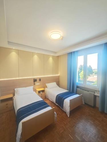 a hotel room with two beds and a window at Hotel Ristorante Oro in Cento