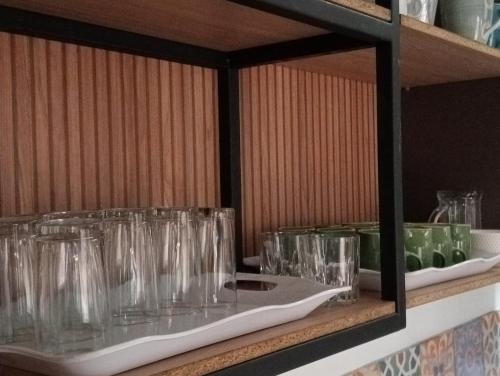 a shelf filled with glasses on a table at Hostal Patio del Río in Cali