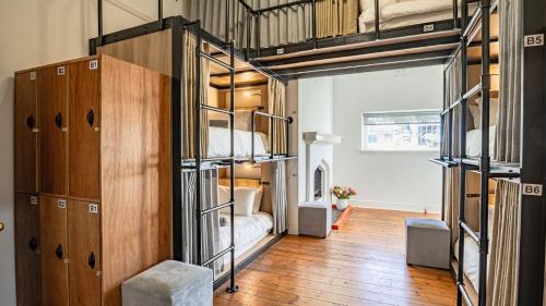 a room with two bunk beds and a bedroom at Adamastor Backpackers in Muizenberg