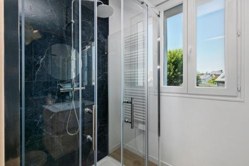 a glass shower in a bathroom with a window at Les terrasses de Joce in Batz-sur-Mer