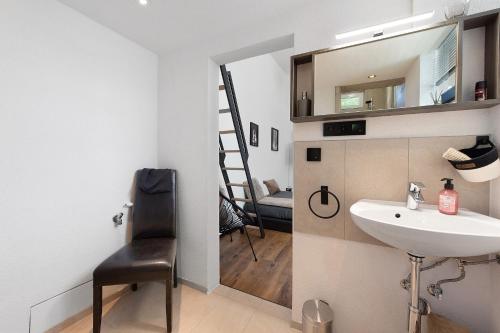 ein Badezimmer mit Waschbecken, Spiegel und Stuhl in der Unterkunft myraybay. in Stockach