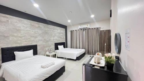 a bedroom with two beds and a desk with a mirror at The one residence in Ban Nong Phak Nam