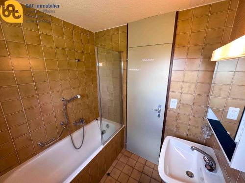a bathroom with a shower and a tub and a sink at Scierie A Meya 118 - Appartement charmant proche des télécabines et du village in Vercorin