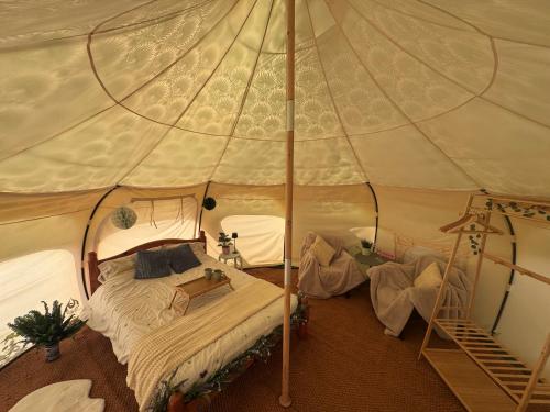 a bedroom with a bed in a tent at Sunrise Tent in Sageau