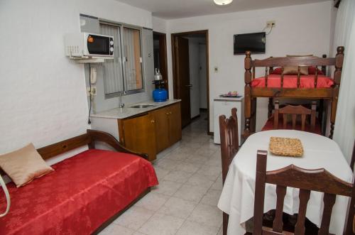 a room with a bed and a table and a kitchen at Apart Hotel Natural del Daymán in Salto