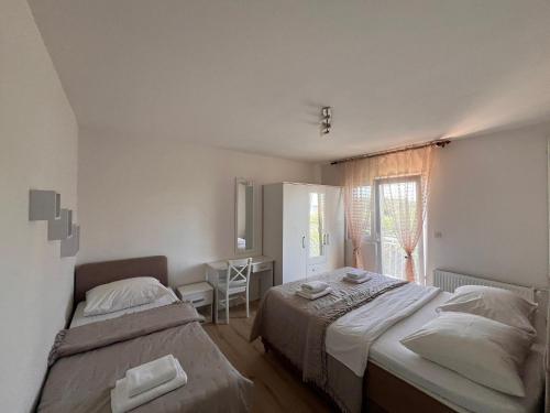 a bedroom with two beds and a desk and a window at Grgo Apartments in Drage