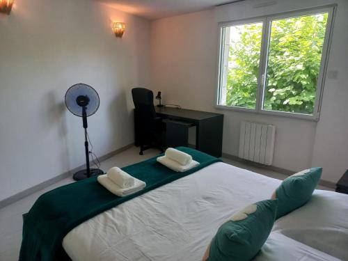 a bedroom with a bed and a desk and a window at La troglo aux oiseaux in Montrichard