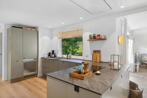 a kitchen with white walls and a large counter top at Newly Renovated And Modern Cottage Near The Beach in Hornbæk