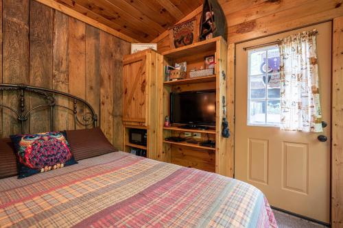a bedroom with a bed and a television in a cabin at The Owl's Perch in Robbinsville