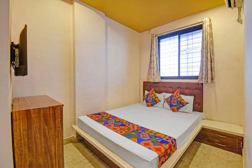 a small bedroom with a bed and a window at Via Kamal Stay Inn in Alandi