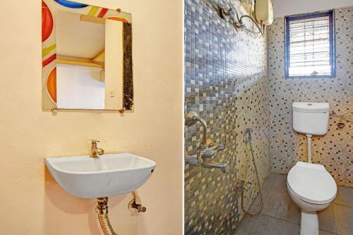 a bathroom with a sink and a toilet and a mirror at Via Kamal Stay Inn in Alandi