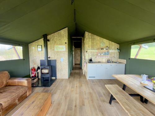 a room with a couch and a table and a kitchen at Brocklands Farm Glamping in Petersfield
