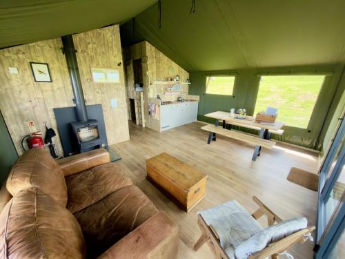 a living room with a couch and a table at Brocklands Farm Glamping in Petersfield