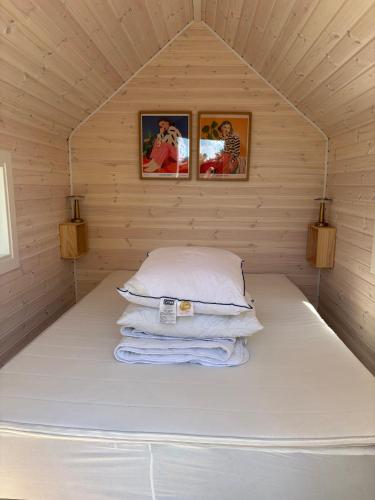 a bed in a small room with two pictures on the wall at Summer House Near The Sea And Good Experiences in Børkop