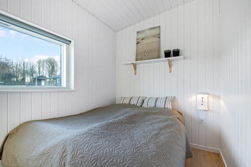 a small bedroom with a bed and a window at New Modern Holiday Home Near The Beach in Aabenraa