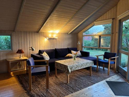 a living room with a couch and a table and chairs at Family-Friendly Cottage Near The Beach in Gilleleje