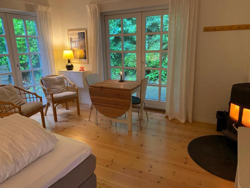 a bedroom with a bed and a table and chairs at Idyllically Situated Wooden House By The Forest in Viborg