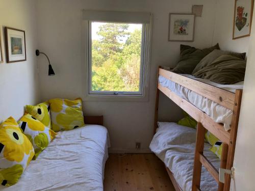 a bedroom with two bunk beds and a window at Nice Summer House With Sea View in Jægerspris