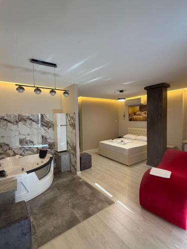a living room with a tub and a bedroom at London Restaurant Hotel in Kukës