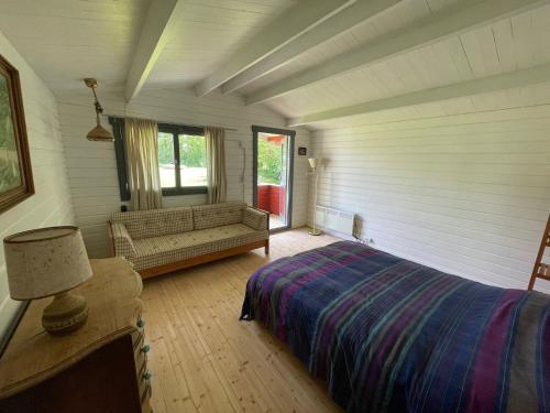 a bedroom with a bed and a window and a couch at Family Friendly Holiday Home In Orø in Holbæk