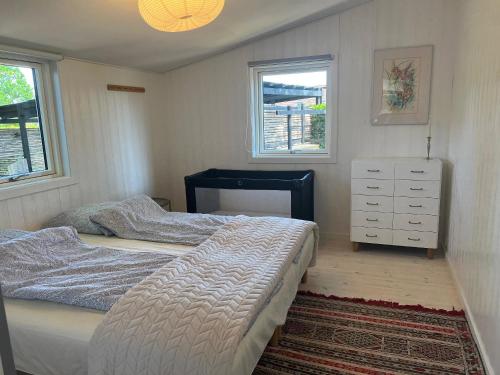 a bedroom with two beds and a dresser and two windows at Relaxing Sanctuary In Desirable Area in Hornbæk