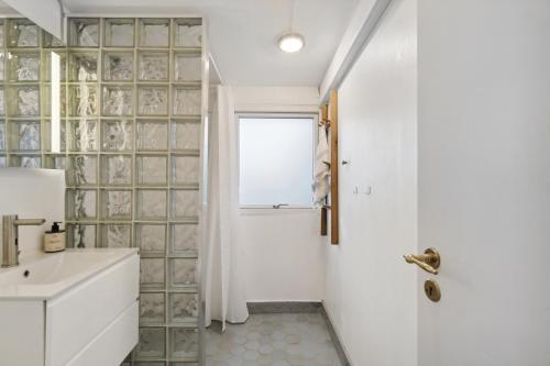 a bathroom with a sink and a window at Relaxing Sanctuary In Desirable Area in Hornbæk