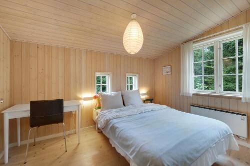 a bedroom with a bed and a desk and windows at Beautiful House 1St Row To The Water in Fur