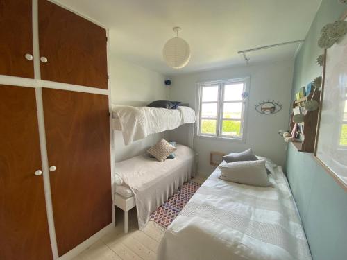 ein Schlafzimmer mit zwei Betten und einem Etagenbett in der Unterkunft Gemütliches Ferienhaus Im Sommerdorf Kerteminde in Kerteminde