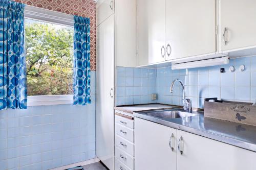 a kitchen with a sink and a window at Cottage By Veddinge In Charming 70S Style in Fårevejle