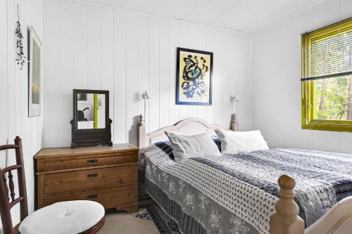 a bedroom with a bed and a mirror on a dresser at Cottage By Veddinge In Charming 70S Style in Fårevejle