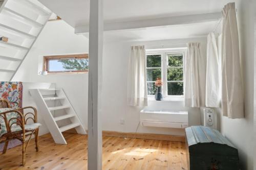 ein weißes Zimmer mit einem Bett und einem Fenster in der Unterkunft Unique Private Idyll in Vesterborg