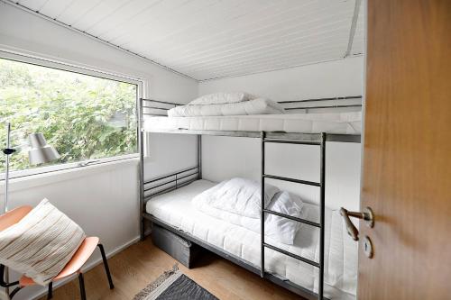 a bedroom with two bunk beds and a window at Charming House With Big Private Terrace in Allinge