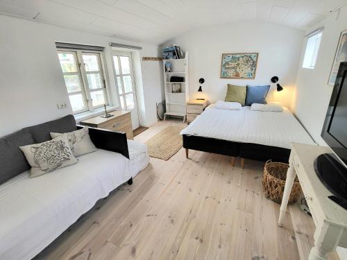 a bedroom with two beds and a couch at Summer House In Årsdale With A Beautiful Sea View in Svaneke