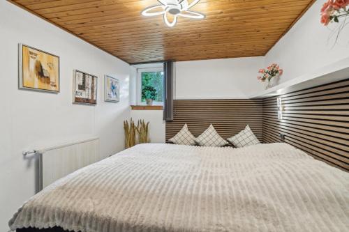 a bedroom with a large bed and a wooden ceiling at Child-Friendly Cottage With Large Indoor Pool in Otterup