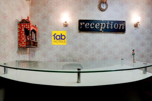 a glass table in a room with signs on the wall at FabHotel DP International in Patna