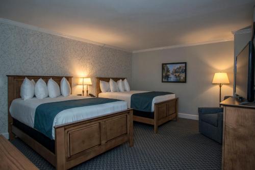 a hotel room with two beds and a television at The Spa at Norwich Inn in Norwich