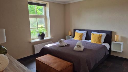 a bedroom with a bed with towels on it at Landhuis onder de lindeboom in Losser