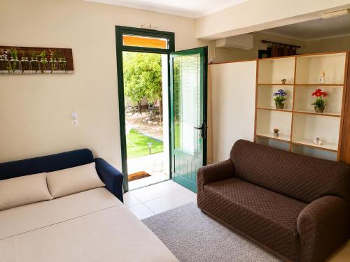 a living room with a couch and a sliding glass door at Nefeli’s guest house in Nydri