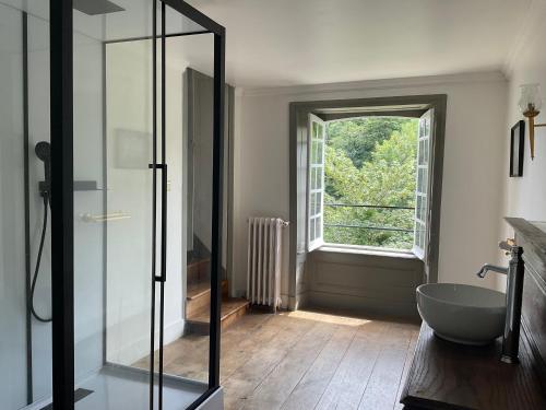 a bathroom with a glass shower and a window at Château de Saint-Pois in Saint-Pois
