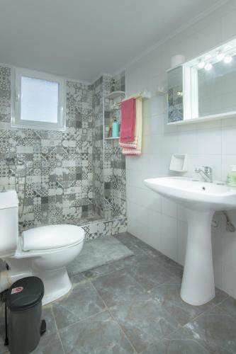 a bathroom with a white toilet and a sink at StayinPyrgi in Pyrgi