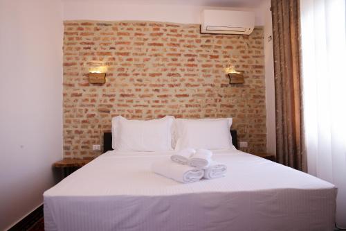 a bedroom with a white bed with towels on it at Moin Moin Boutique Hotel in Berat