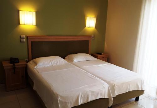 a bedroom with a bed with white sheets and two pillows at Sea Sight Boutique Hotel in Porto Rafti