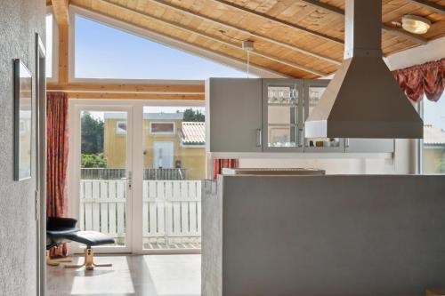 a kitchen with a view of a balcony at Pool House Close To The Coast in Vestervig