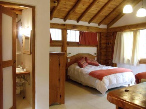 a bedroom with a bed in a room with wooden ceilings at Patagonia Playa Cielo in Mar de las Pampas