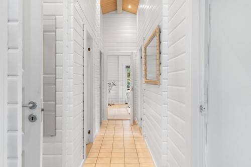 a hallway with white walls and a tile floor at Summer Cottage With Jacuzzi And Sauna in Fakse Ladeplads