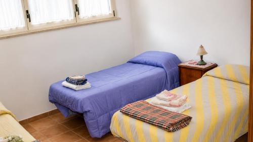 a bedroom with two beds and a table with a lamp at Casa Vacanze Agriturismo BioMele in Policoro