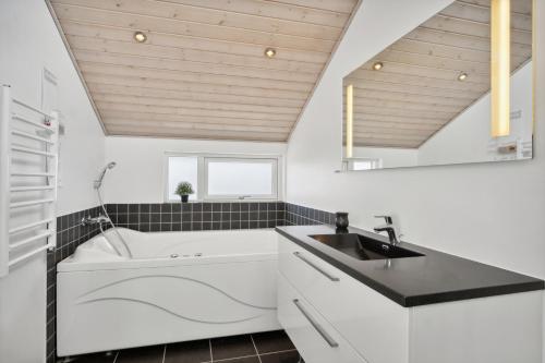 a bathroom with a sink and a bath tub at Lovely Summer House In Haderslev in Haderslev