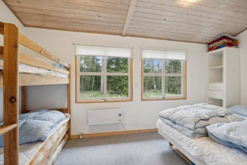 two bunk beds in a room with two windows at Pool House With Space For Relaxation in Bording Stationsby