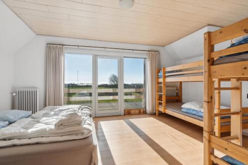 a bedroom with two bunk beds and a large window at House For 40 People Near Thy in Gettrup